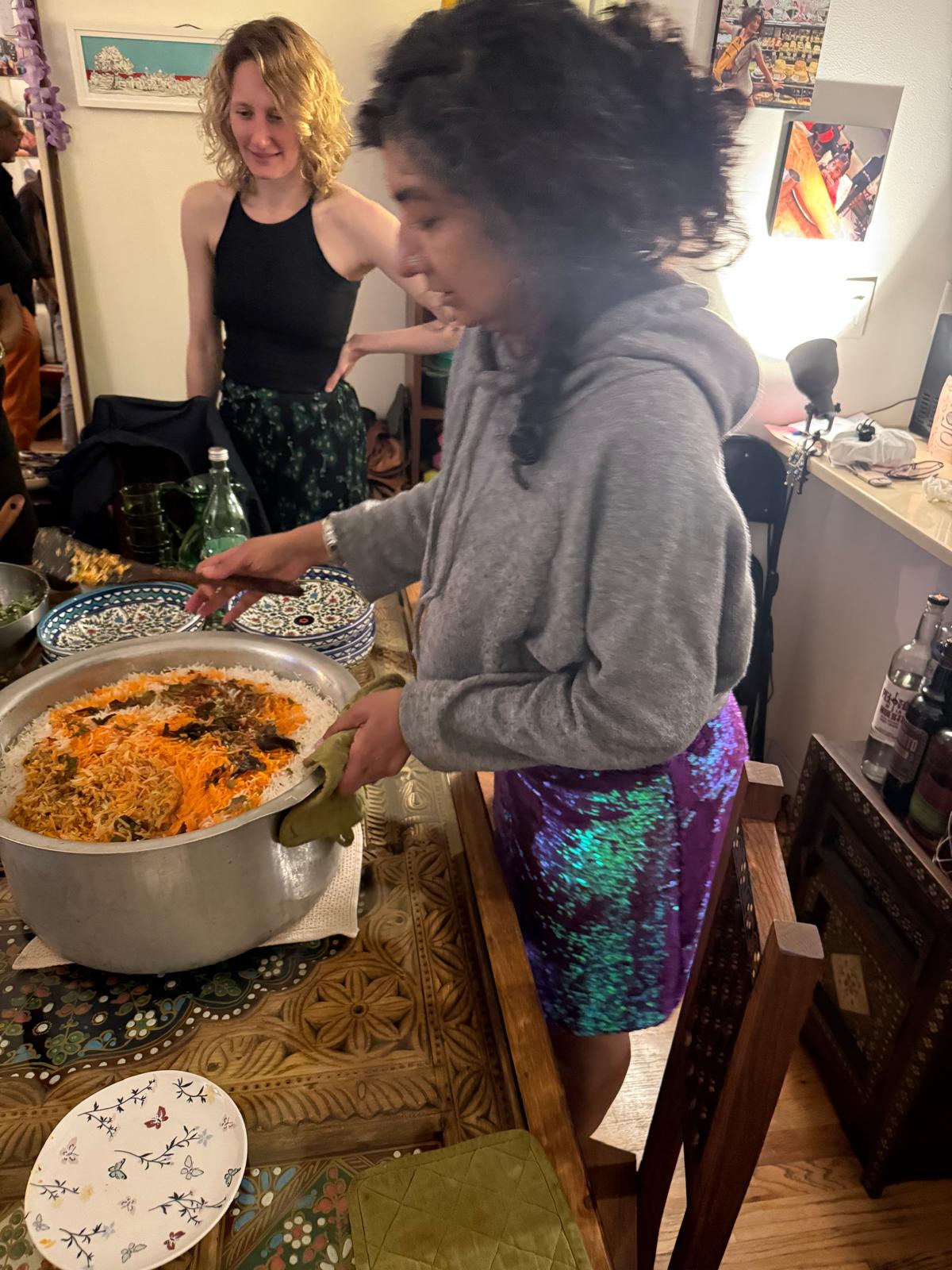 Zehra serving biryani from a large pot at a gathering